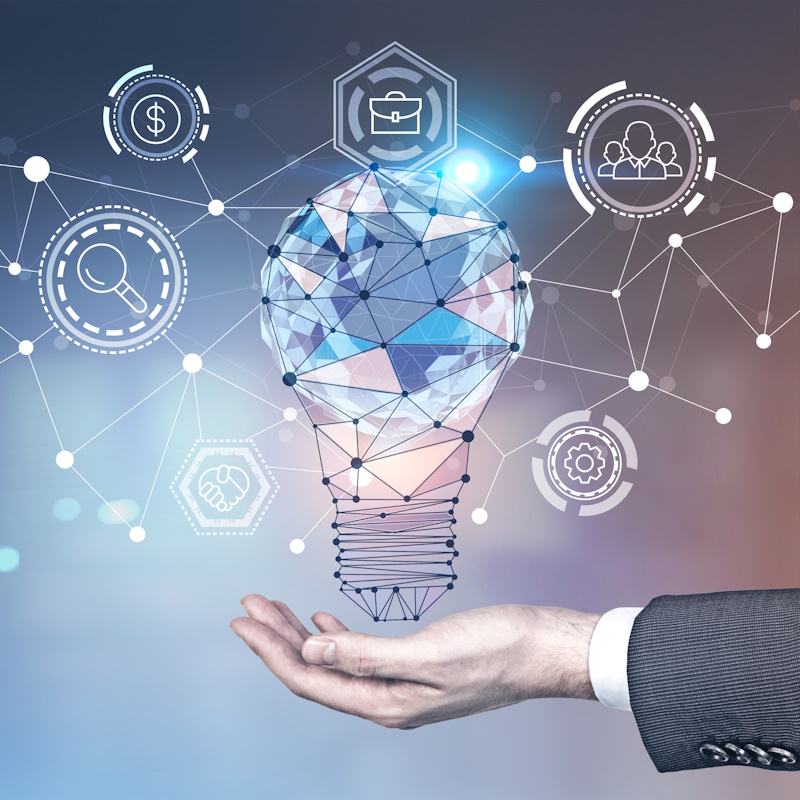 Man hand, glowing light bulb, network interface An image of a hand with a polygonal light bulb and other tech related icons floating above the hand.