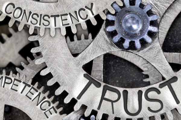 An image of cogs with words inscribed on them such as "Trust".