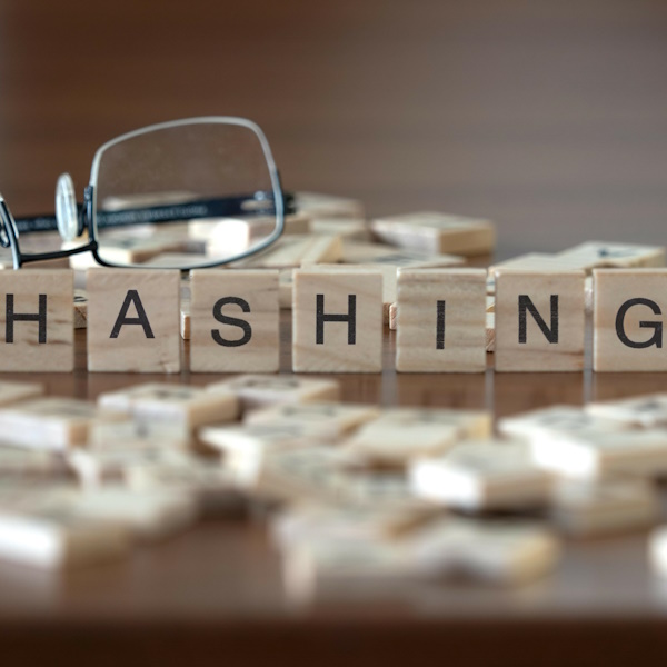 An image of wood blocks that spell hashing, and a pair of glasses in the background.