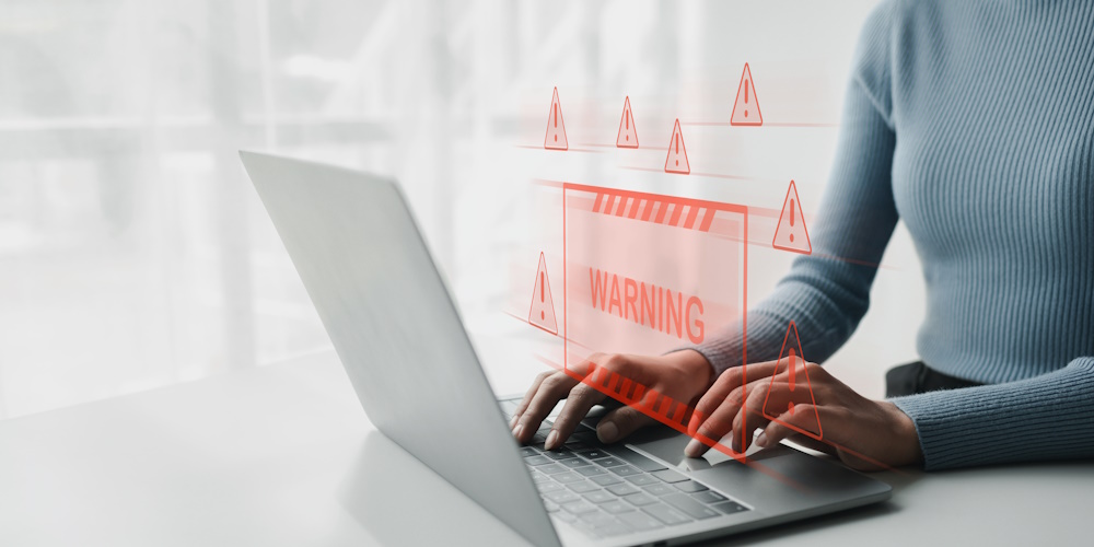 An image of a computer user being warned of a potential attack, represented by a red box that reads "WARNING."