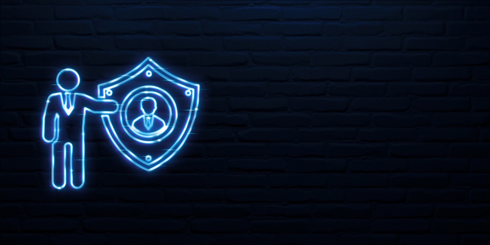 An image that looks like a neon sign of a person in a suit presenting a shield with the silhouette of a person on the shield representing zero trust security.