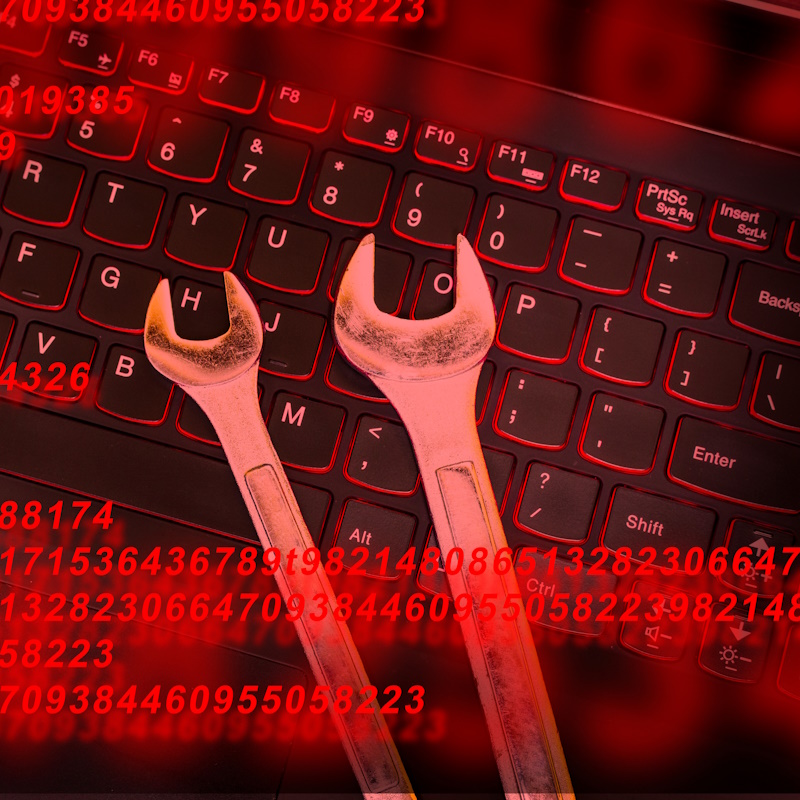 An image with numbers spanning across the foreground, and two wrenches laying on top of a laptop keyboard.