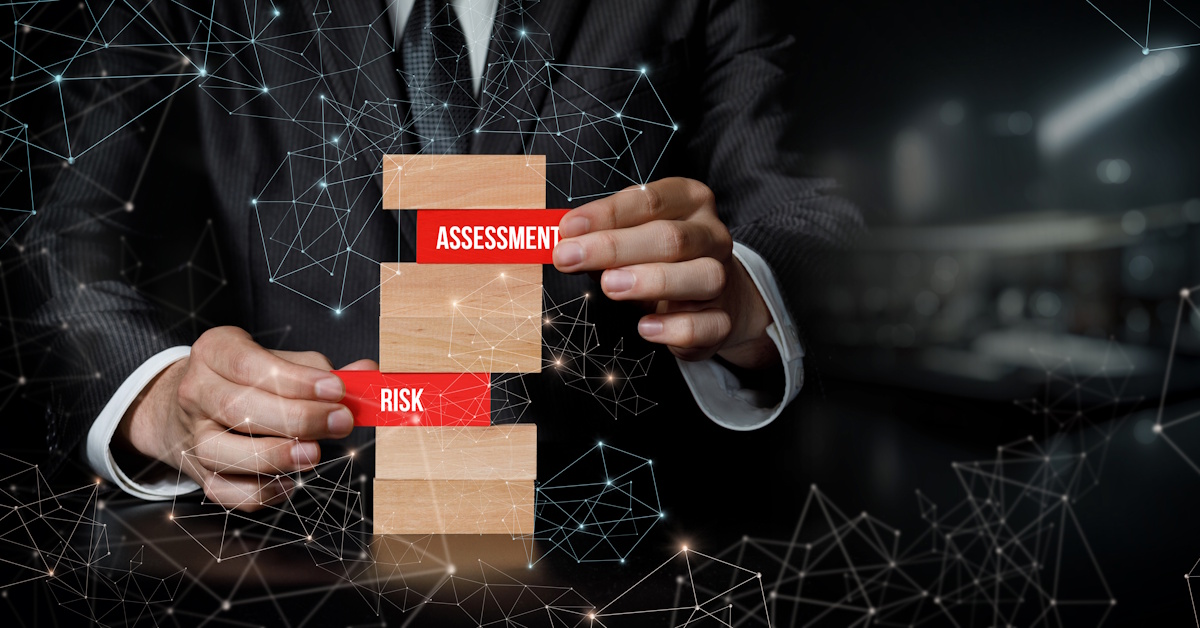 An image of a man pulling blocks out from a Jenga tower which read "risk assessment."