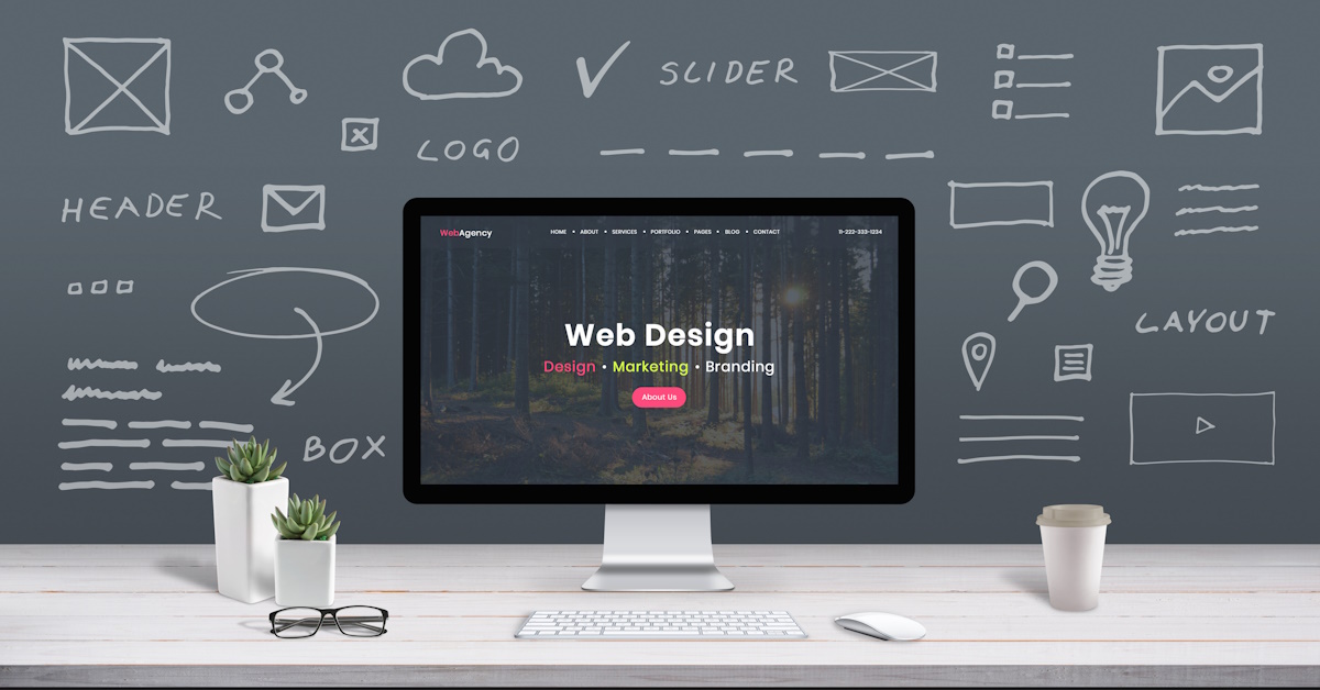 An image of a PC that reads web design and is surrounded by different aspects of web design written on a chalk board