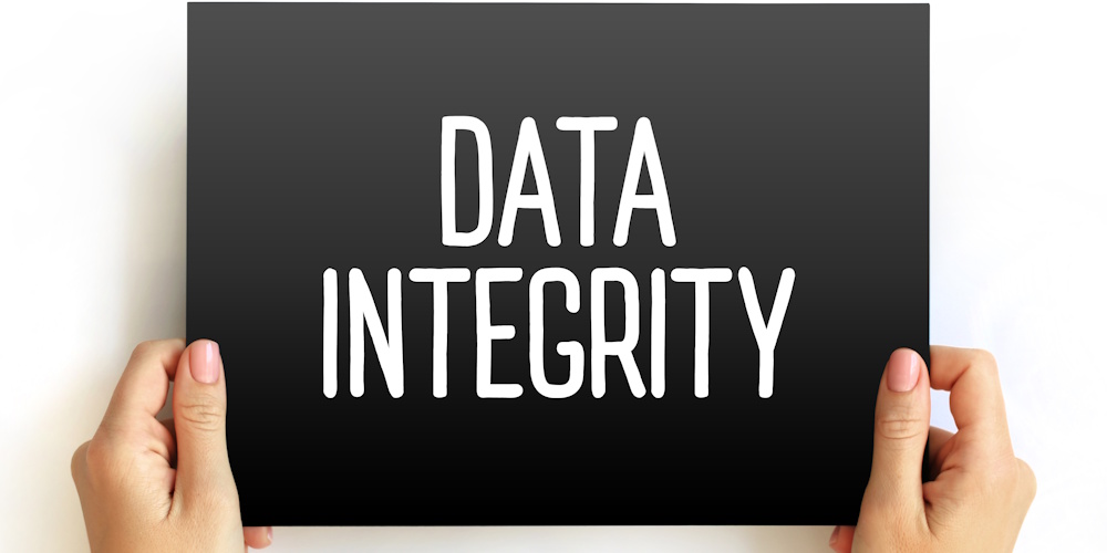 An image of hands holding a sign that reads "data integrity"