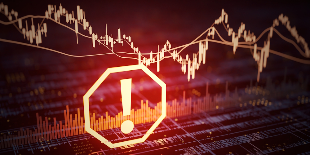 Warning symbol with an exclamation mark overlaying a declining stock market graph.