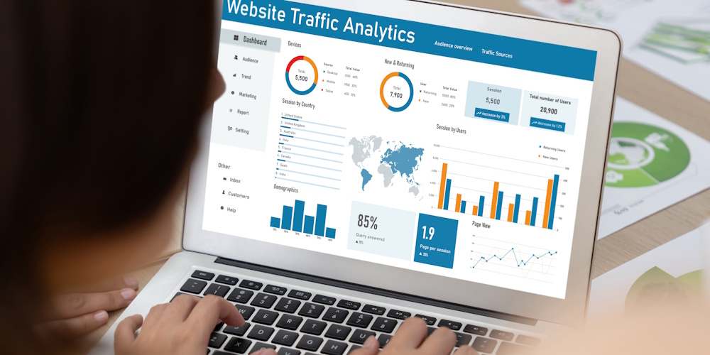 An image of a woman looking at website traffic analytics on her laptop.