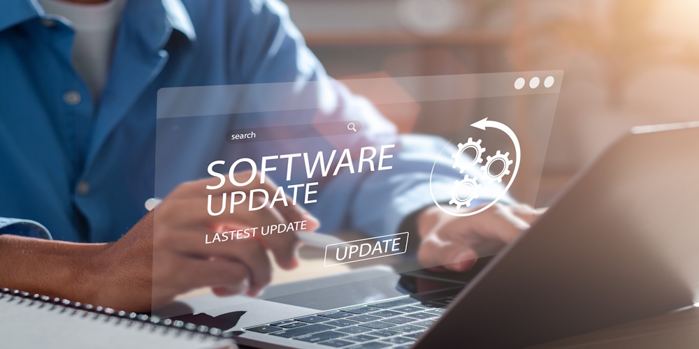 A person using a laptop with a digital overlay displaying a software update notification and gear icons.