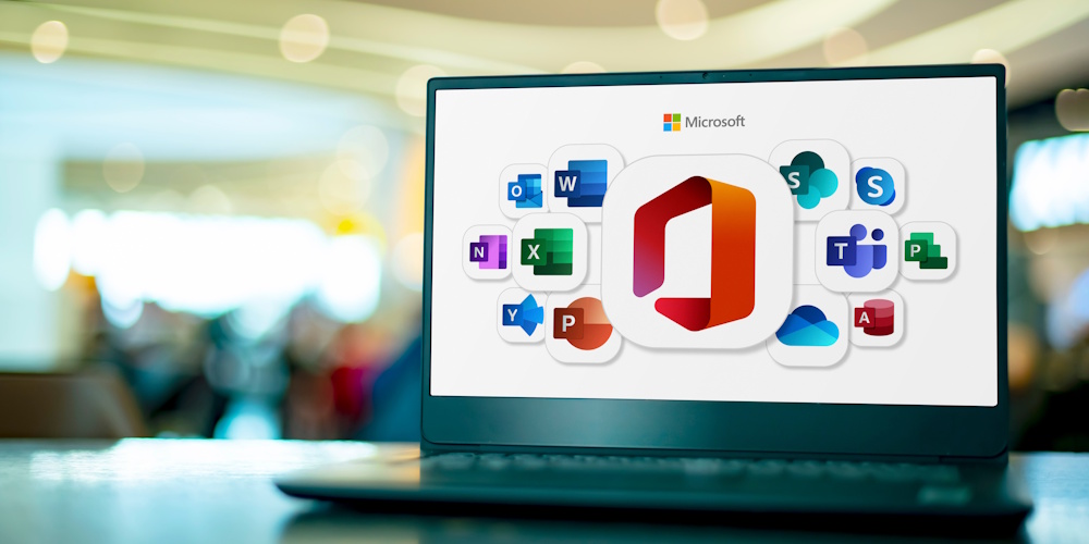 M365MigrationPic3_534920982_Editorial_Use_Only Laptop computer displaying logos of Microsoft Office, a family of client software, server software, and services developed by Microsoft